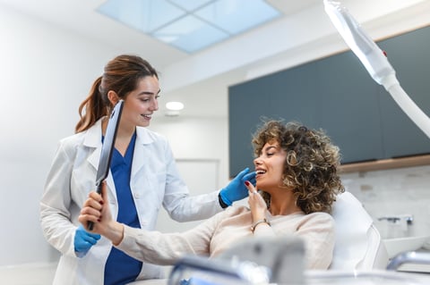 Patient looking at results in mirror with aesthetic medical professional